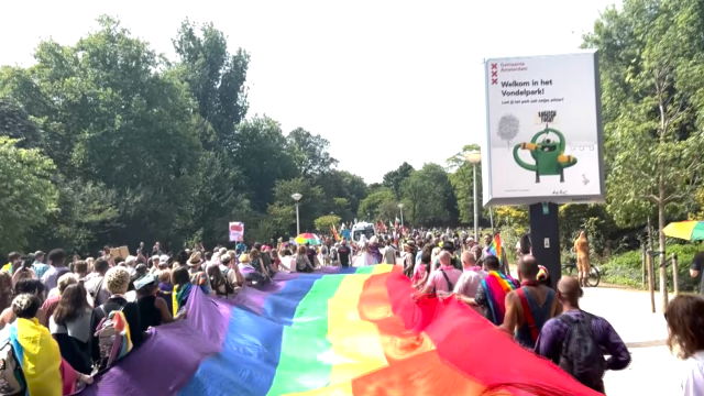 Rainbow flag meets 71 Zero flags at the entrance of the Vondelpark during the PrideWalk of Pride Amsterdam.